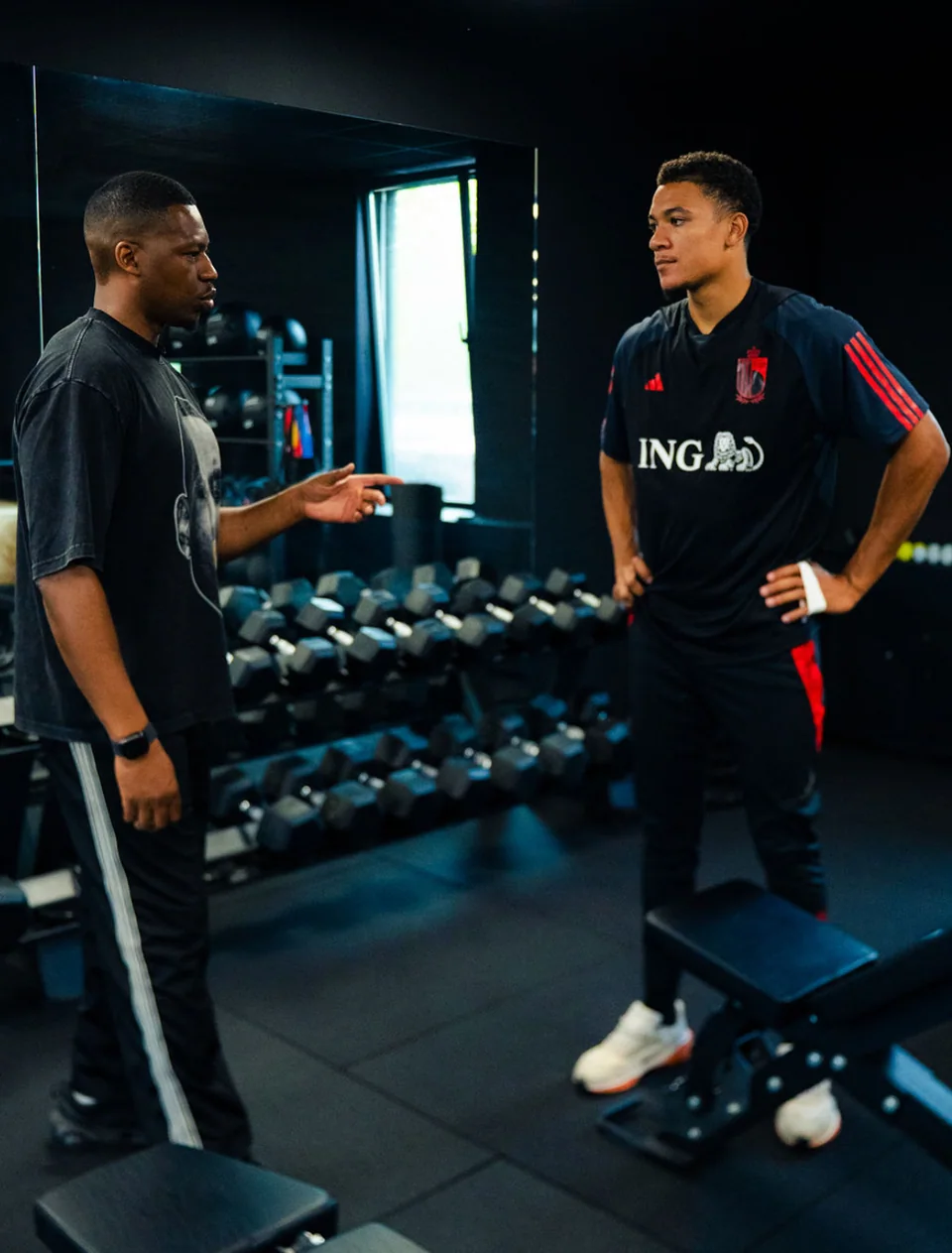 Échange entre un accompagnant et un joueur dans une salle d’entraînement.